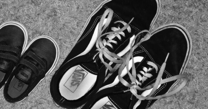 Black and white photo of adult and child shoes