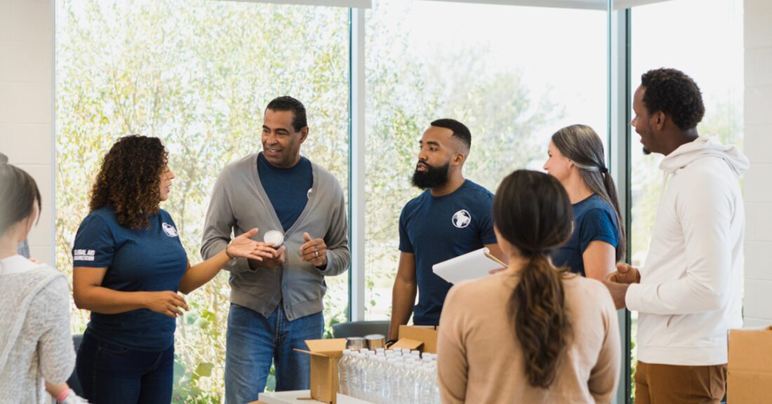 A group of nonprofit workers chat and organize around a table.