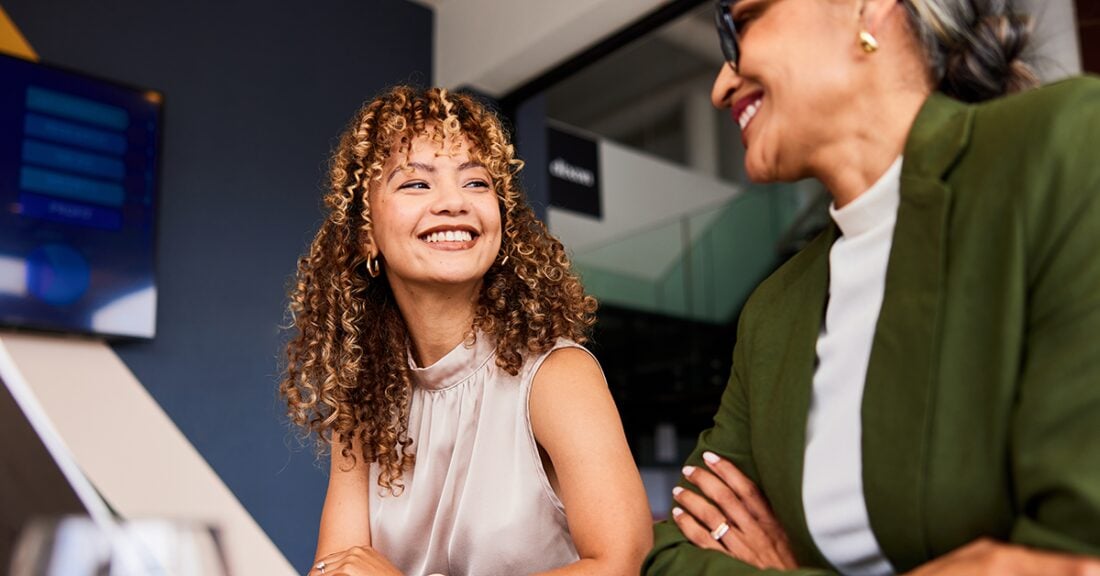 A young employee smiles at her female boss.