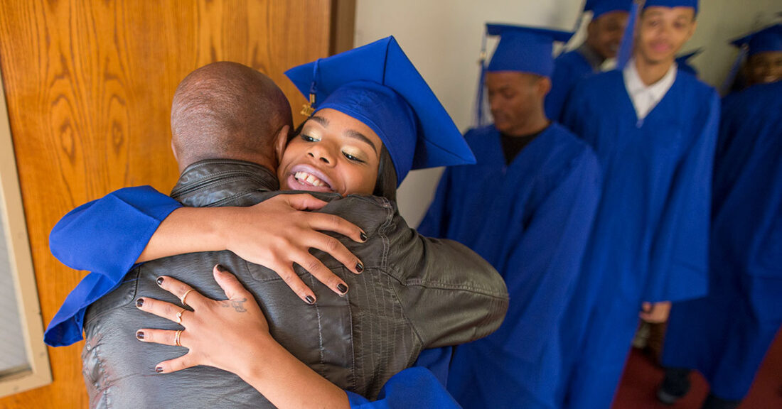 High school graduate greets a family member