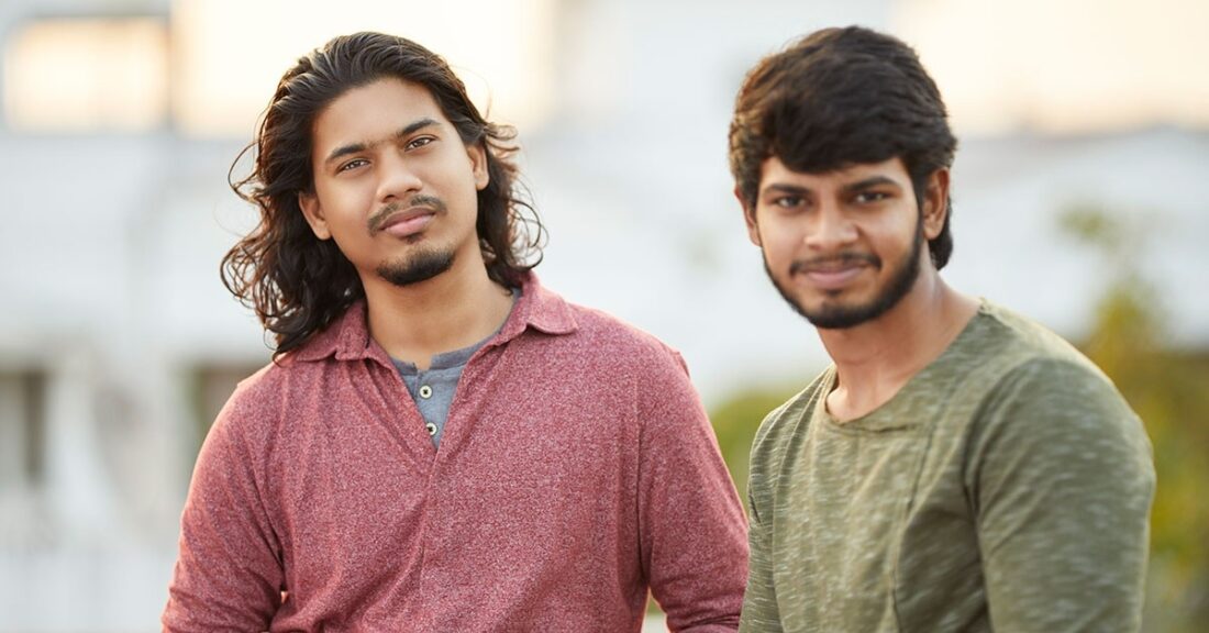 Two young men, who are of either Latino or Indigenous descent, smile at the camera.