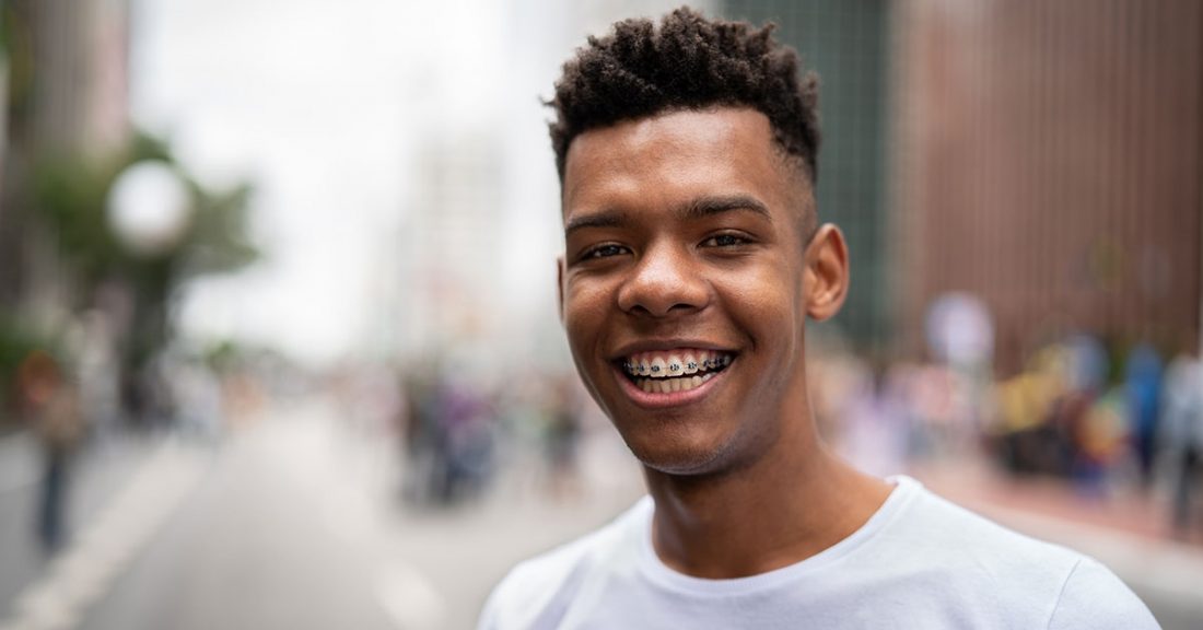Young person with braces smiles