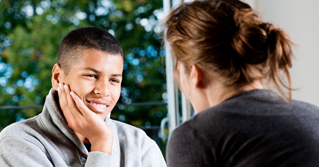 Young person talking with a supportive teacher