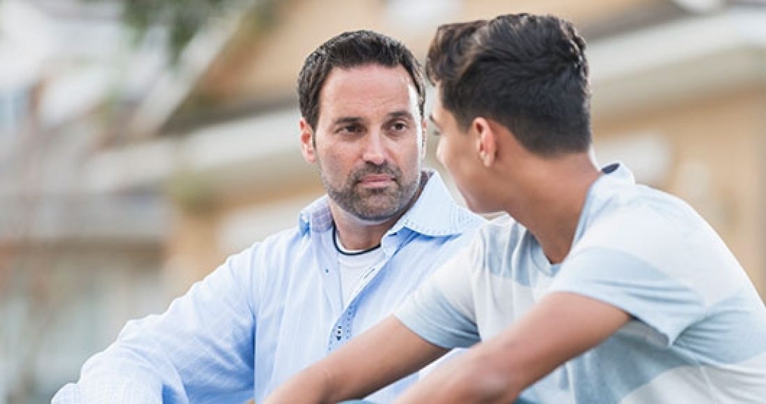 Immigrant father talking with teenage son.