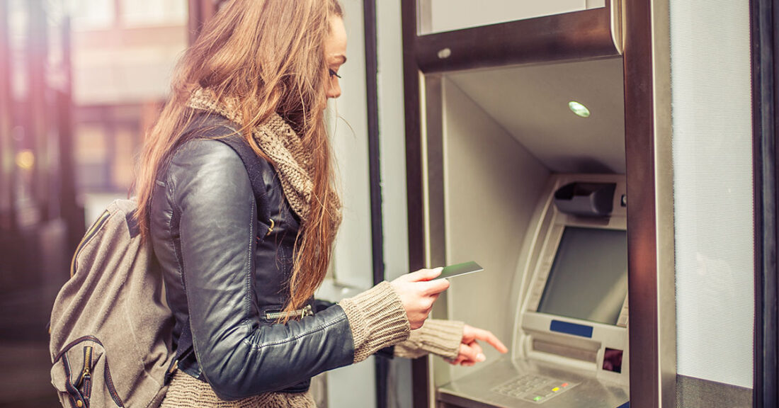 Young woman at ATM machine.