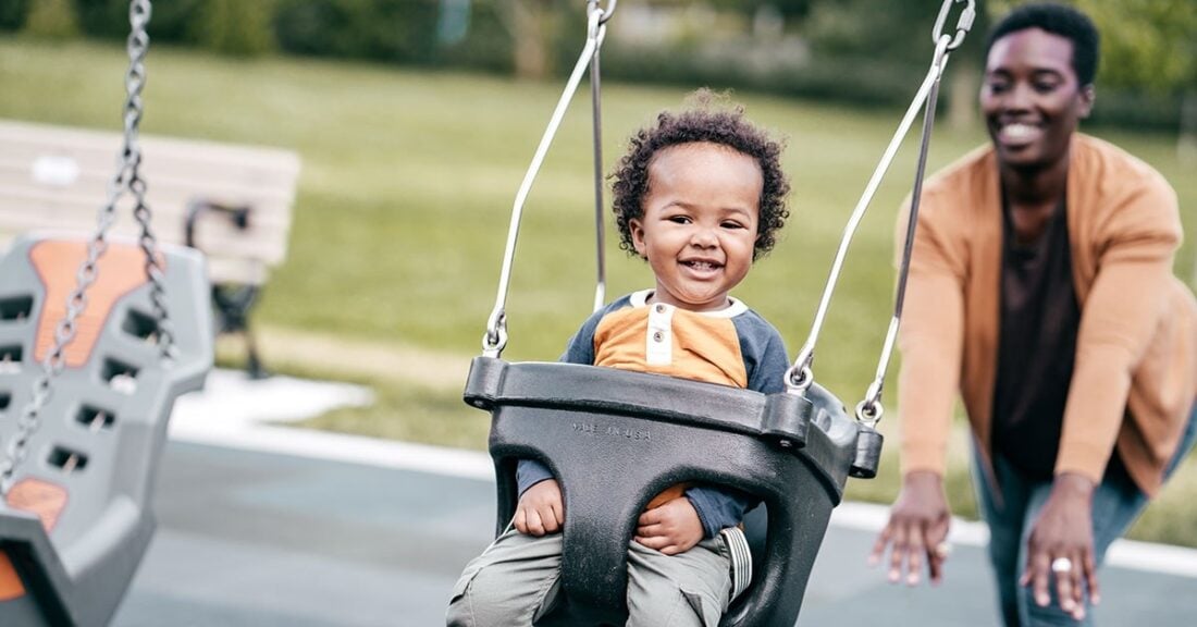 Child on swing with mom pushing her