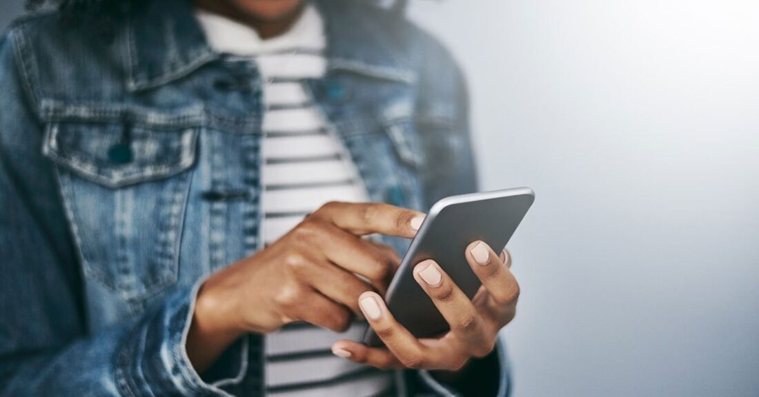 Close-up shot of a woman of color using her cell phone.