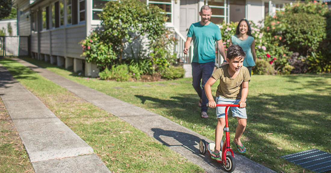 Parents with a young person on a bicycle.