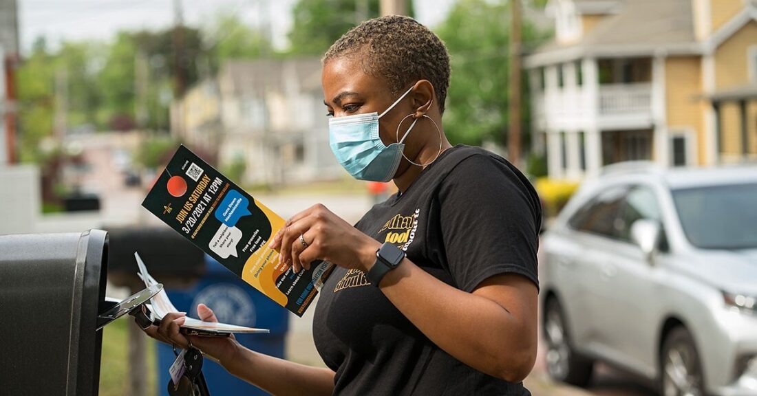 Community member holds pamphlets about reducing violence