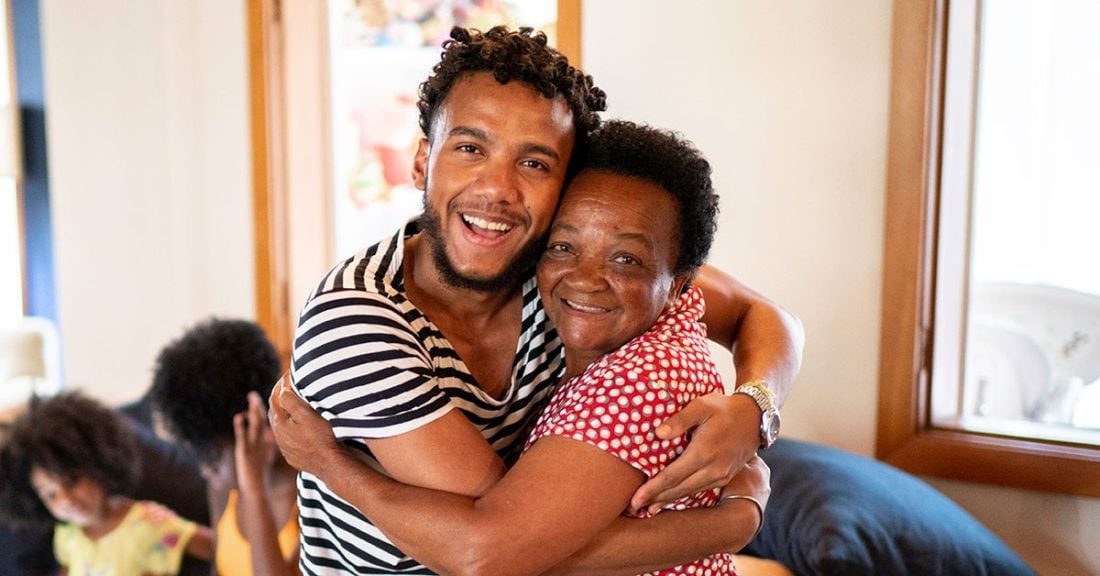 Young Black man holds older Black woman