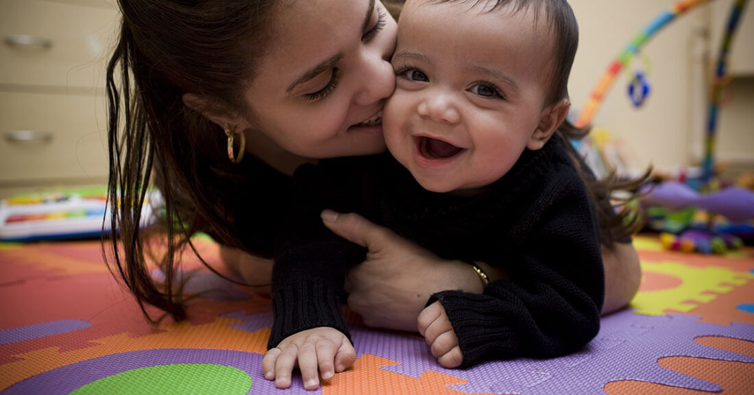 Young mother holding her smiling baby