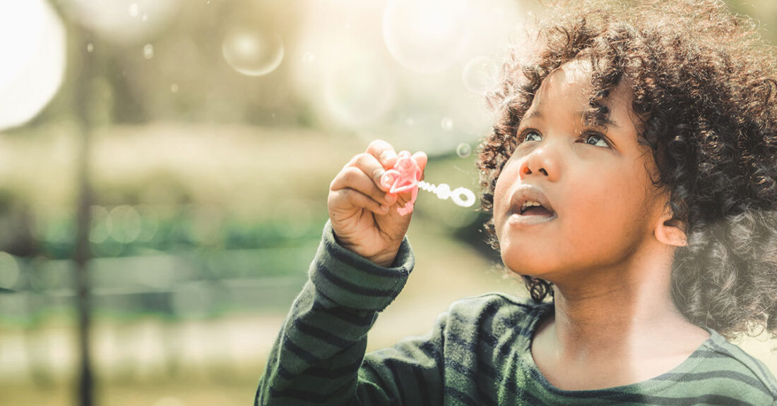 Young child plays with bubbles