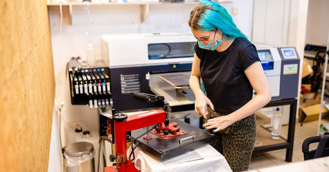 Young person learns how to use a machine through an apprenticeship program