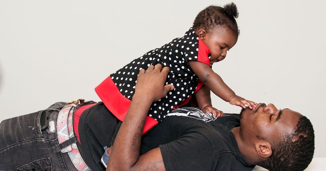 Daughter plays with father on the floor