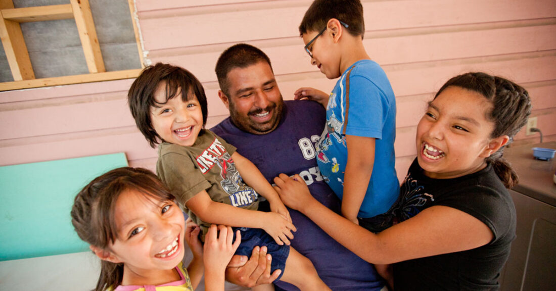 Father surrounded by four children