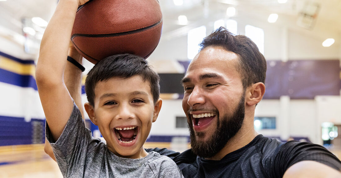 Young father spends time playing basketball with son