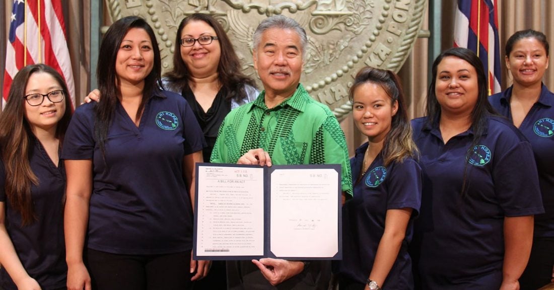 Governor David Y. Ige with youth advocates during the signing ceremony on the rights of children in foster care.