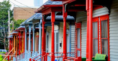 A line of brightly trimmed homes on one side of the street.