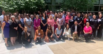 Group photo of past participants in the Transforming Juvenile Probation Certificate Program posing outdoors.
