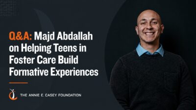 A smiling man on the right side of the image with the words "Q&A: Majd Abdallah on Helping Teens in Foster Care Build Formative Experiences" on the left side of the image.