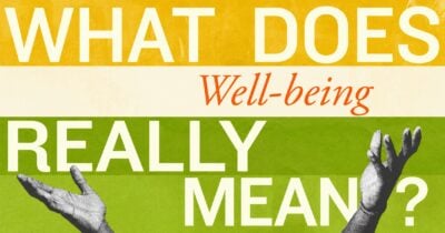 A laptop displays a colorful graphic that asks, “What does well-being really mean?” inside a classroom.