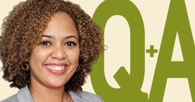 Smiling woman with curly hair, wearing earrings and a light blazer, in front of a graphic background with large green letters ‘Q+A’