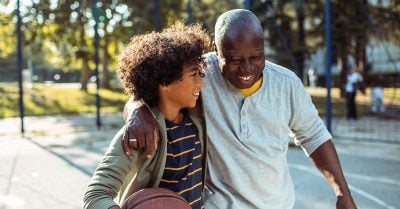 Grandfather raising his grandson play basketball