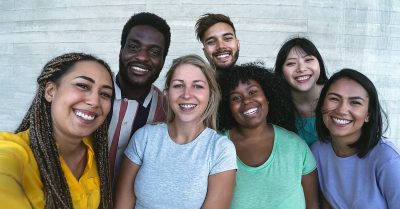 A racially diverse group of seven smiling young people.
